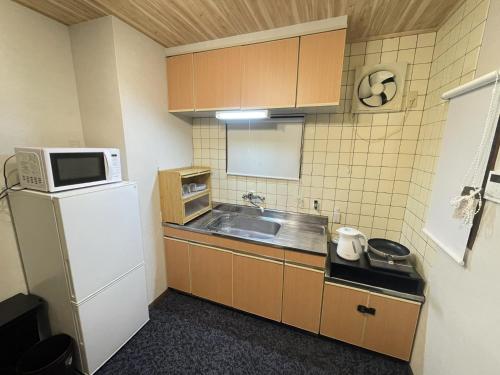 a small kitchen with a sink and a refrigerator at Guest house TOMORI - Vacation STAY 11064v in Shingū
