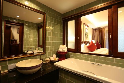 a bathroom with a large tub and two mirrors at Viangluang Resort in Chiang Mai