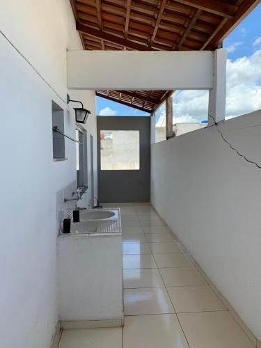 a bathroom with a sink in a white wall at Green House Apartamentos in Ubá