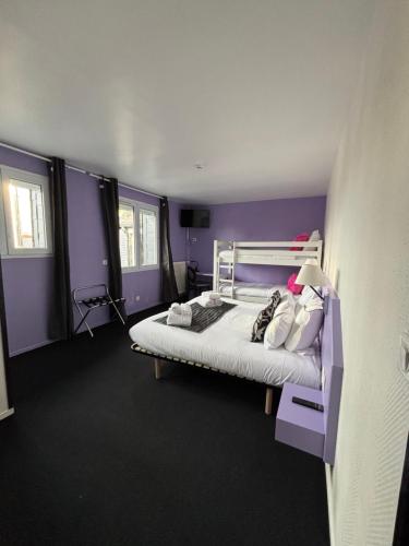 a bedroom with a bed with purple walls at Hôtel - Restaurant Eugenie in Pontorson