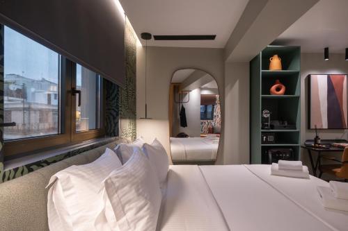 a bedroom with a white bed with a large window at Athens Retro in Athens