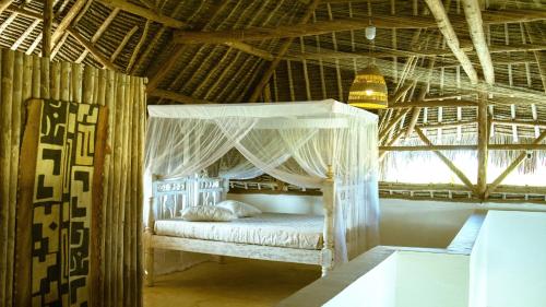 a bedroom with a bed with a canopy at Nyumba ya Bubi in Watamu