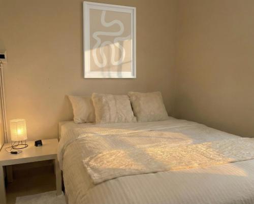 a bedroom with a bed and a table with a lamp at Hostel Bangkok Airport Comfort By MaTong " Near Suvarnabhumi Airport BKK " in Suvarnabhumi Airport