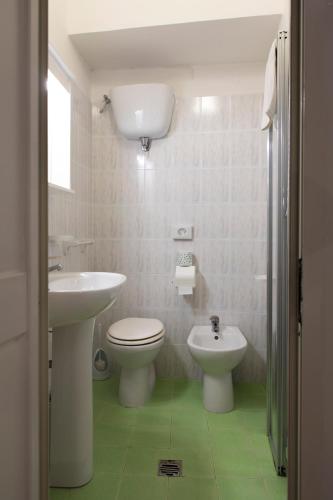 a bathroom with a sink and a toilet and a bidet at Hotel Il Vicoletto in Assisi