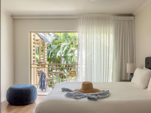 a bedroom with a bed with a hat on it at Mantra Amphora in Palm Cove