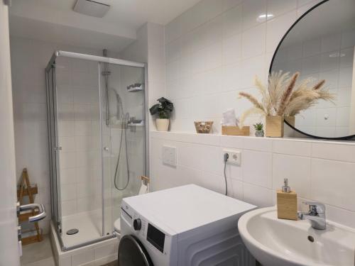 a bathroom with a sink and a washing machine at Große Wohnung nahe München in Ismaning