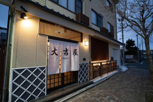 a building with a sign on the side of it at 大吉屋本館 ワンフロア貸切部屋 名駅離れ in Nagoya