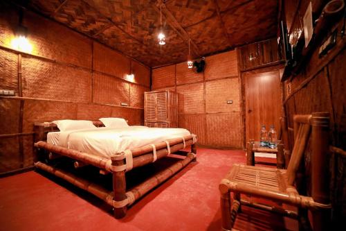 a bedroom with a bed in a wooden room at Bali Bamboo Resort in Padinjarathara