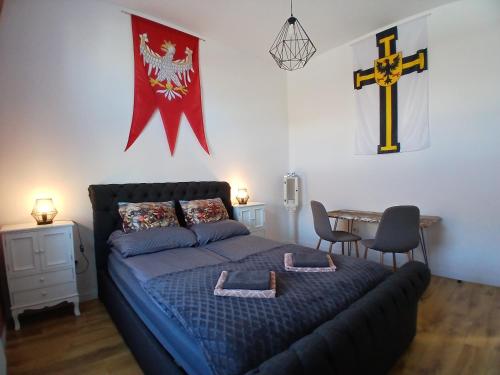 a bedroom with a bed with a cross on the wall at Apartamenty Zakonne "Apartament Komtura" in Malbork