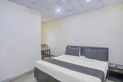 a bedroom with a large bed with blue pillows at Collection O Green Park Residency 3 in New Delhi