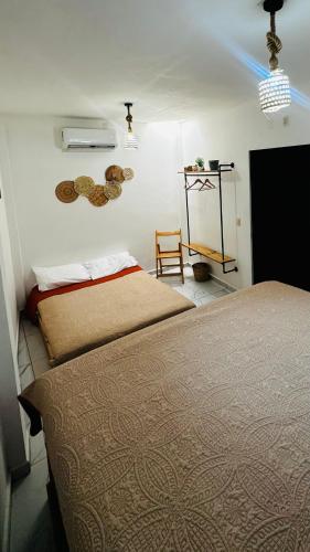 a bedroom with two beds and a table and a chair at Baru chachalacas in Chachalacas