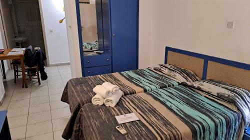 a hotel room with a bed with towels on it at C & A Hotel Apartments in Polis Chrysochous