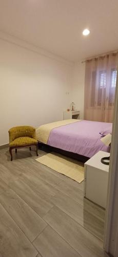 a bedroom with a bed and a chair and a table at La Suite del Borgo in Bovalino Marina