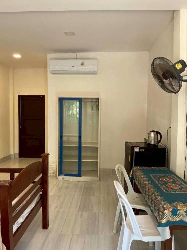 a dining room with a table and a blue door at P&G leampom hotel in Ban Chao Nam
