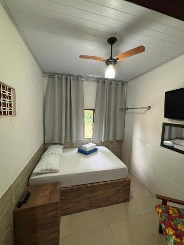 a bed in a room with a ceiling fan at Pouso do Carmo in Pirenópolis