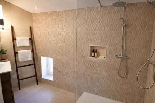 a bathroom with a shower with a glass door at La Grange Blanche in Sault-de-Vaucluse