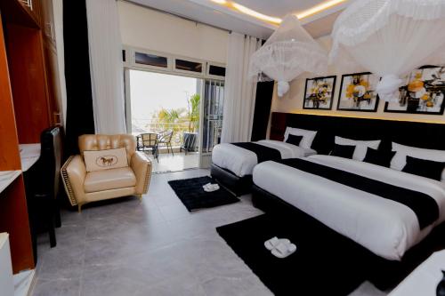 a hotel room with two beds and a chair at One Click Cozy Suites in Kigali