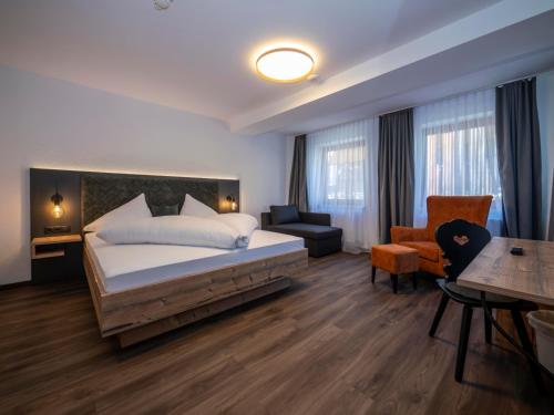 a hotel room with a bed and a desk and chair at Pension Kohler in Fügen