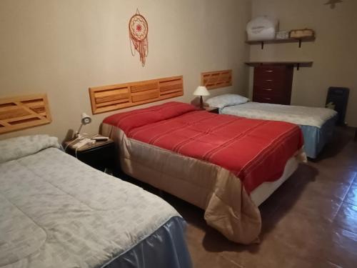 a bedroom with two beds and a dresser at Casa Verdes del Malka in Tilcara