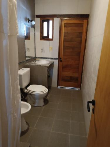 a bathroom with a toilet and a sink and a door at Casa Verdes del Malka in Tilcara