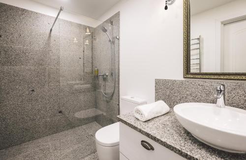a bathroom with a shower and a sink and a toilet at Jacuzzi Romantic Apartment in Klaipėda