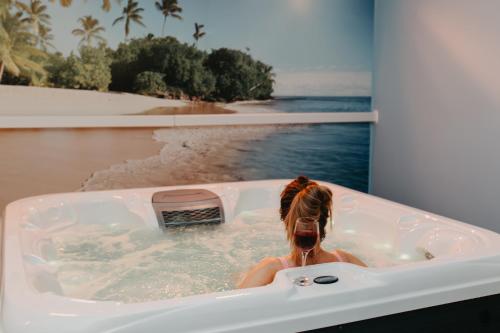 a woman in a bath tub with a view of the ocean at Apartamenty Niegocin in Wilkasy