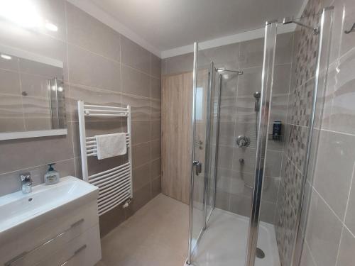 a bathroom with a shower and a sink at Anton Apartmanház in Balatonfüred