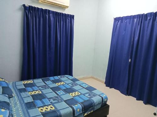 a bedroom with blue drapes and a bed in a room at Hanny Cozy Homestay in Kuala Lipis