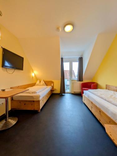 a hotel room with two beds and a desk at Hotel Demling in Randersacker