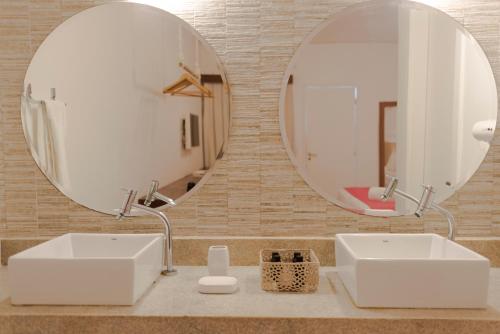 a bathroom with two sinks and a large mirror at Pousada da Villa in Fernando de Noronha
