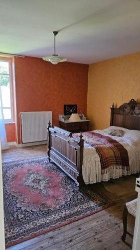 a bedroom with a large bed and a rug at le logis des Chabannes in Saint-Angel