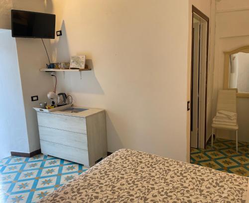 a bedroom with a bed and a dresser and a television at Affittacamere l'Acciuga in La Spezia