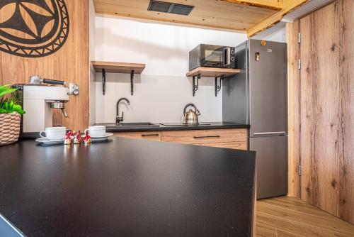 a kitchen with a black counter top and a refrigerator at Good Morning Giewont & JACUZZI in Kościelisko