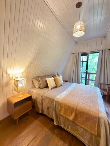 a bedroom with a bed and a lamp in it at Cabana Eucalipto in Itatiaia