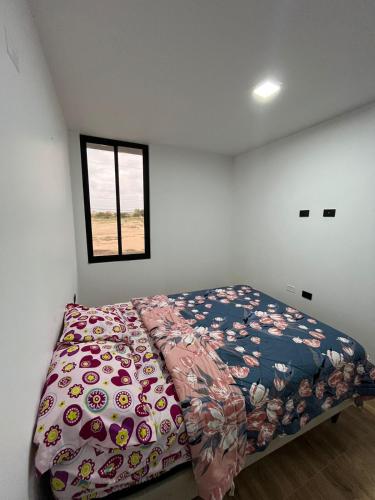 a bedroom with a bed in a room with a window at Pimentel Casa in Chiclayo