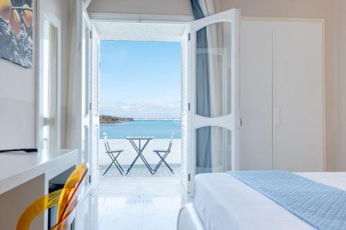 a bedroom with a bed and a view of the ocean at Hotel Lo Scoglio in Porto Cesareo