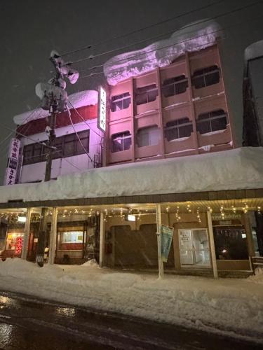 a building is lit up in the snow at night at 湯沢粉雪の宿 in Yuzawa