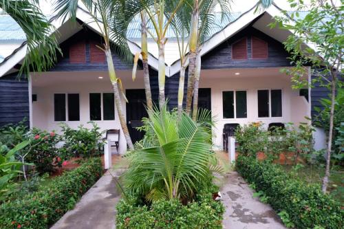 a house with palm trees in front of it at The Krabi Forest Homestay in Ao Nang Beach
