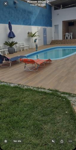 a large swimming pool with tables and chairs next to it at Temporada Monte gordo in Camacari