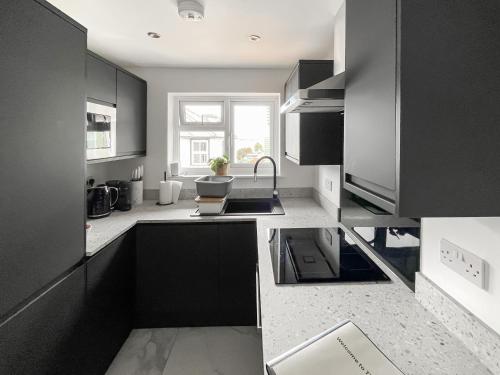a kitchen with black cabinets and a sink at Thirslet in Maldon