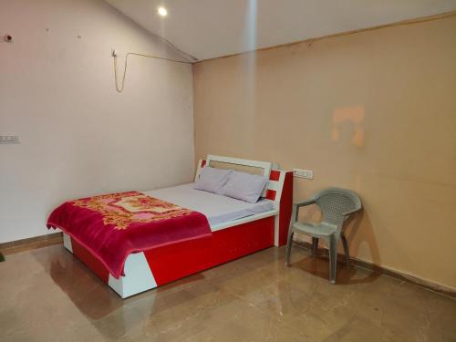 a bedroom with a red and white bed and a chair at Fortune Heritage Resort in Baori Thikria