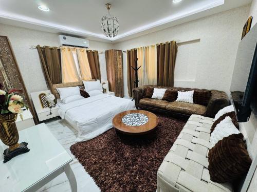 a living room with a couch and a table at Velmora Cozy 2BR Apartment 20 in Abu Dhabi