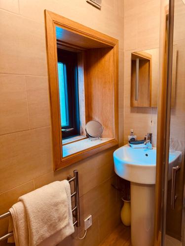 a bathroom with a sink and a mirror at Lakeview Guest House in Stranraer