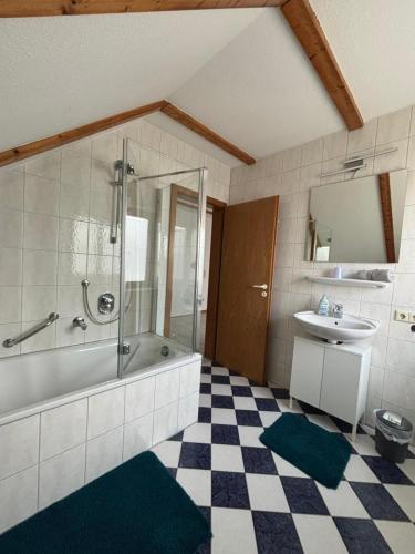 a bathroom with a tub and a sink and a shower at FEWO Eggenstein beim KIT in Eggenstein-Leopoldshafen