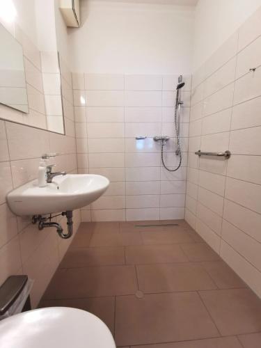 a white bathroom with a sink and a shower at BERNSTEINHAUS in Zingst barrierefreie 2-Raum-Wohnung mit Terrasse - Nr 1 in Zingst