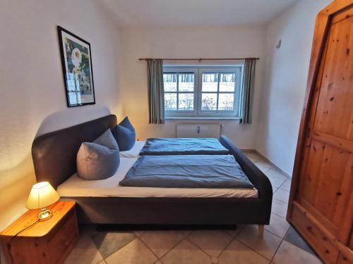 a bedroom with a bed and a window at BERNSTEINHAUS in Zingst barrierefreie 2-Raum-Wohnung mit Terrasse - Nr 1 in Zingst