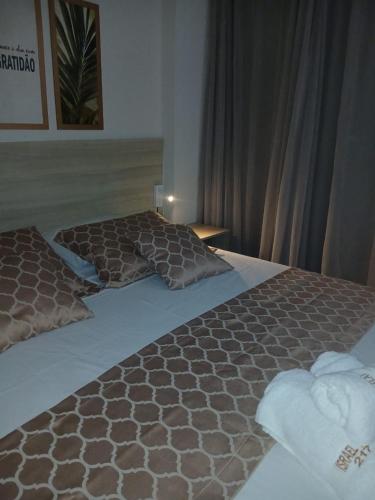 a bedroom with two beds with brown and white sheets at Tambaú Israel Flat 217 - Beira mar in João Pessoa