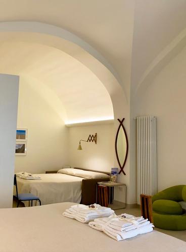a room with two beds and a green chair at Ai Sottani B&B Deluxe Suite in Gioia del Colle