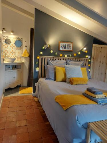 a bedroom with a large bed with yellow pillows at Chez Agatha in Vertheuil-en-Médoc