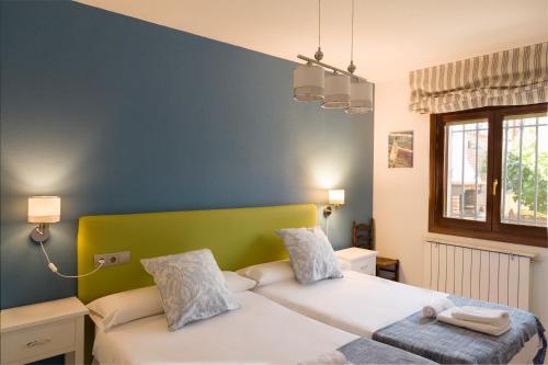 a bedroom with two beds and a blue wall at Casa rural El Laurel in Chañe